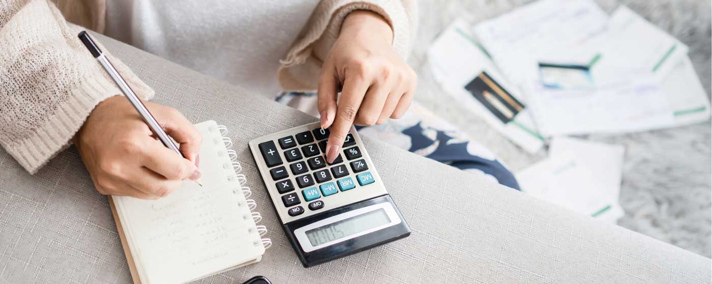 Woman calculating her expenses with calculator
