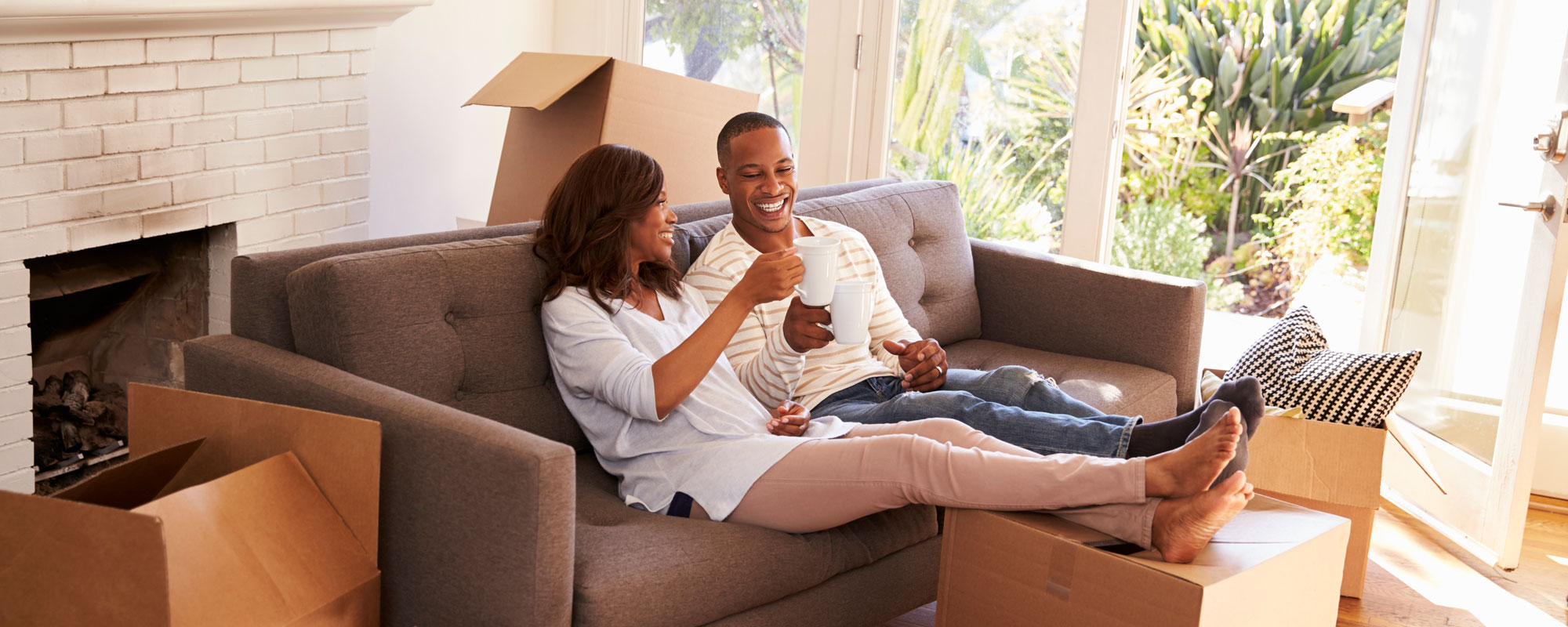 Couple relaxing on couch after unpacking boxes