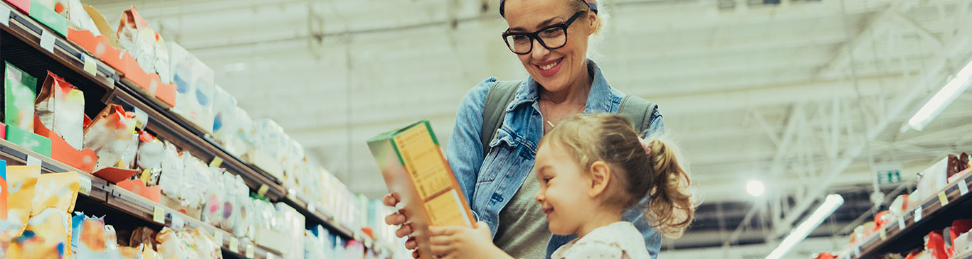 Woman with child in a grocery store looking at cereal box
