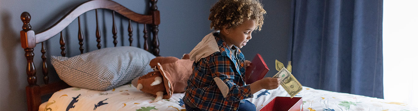 little boy putting cash into box