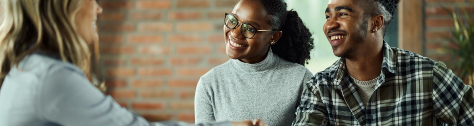 Credit union employee shaking hands with couple