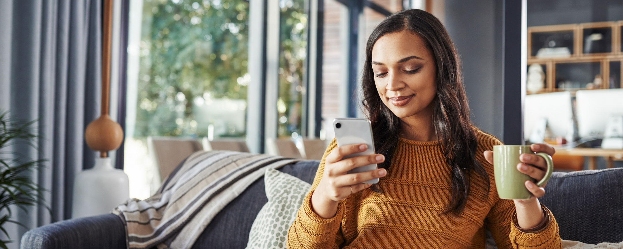Woman looking at phone while sitting on couch