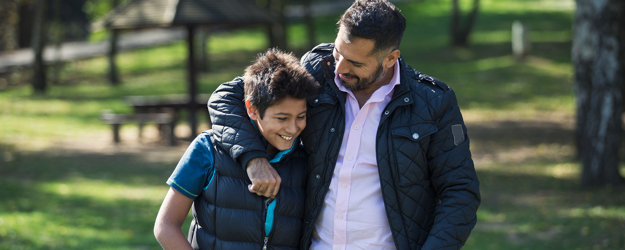 father and son walking outside embraced