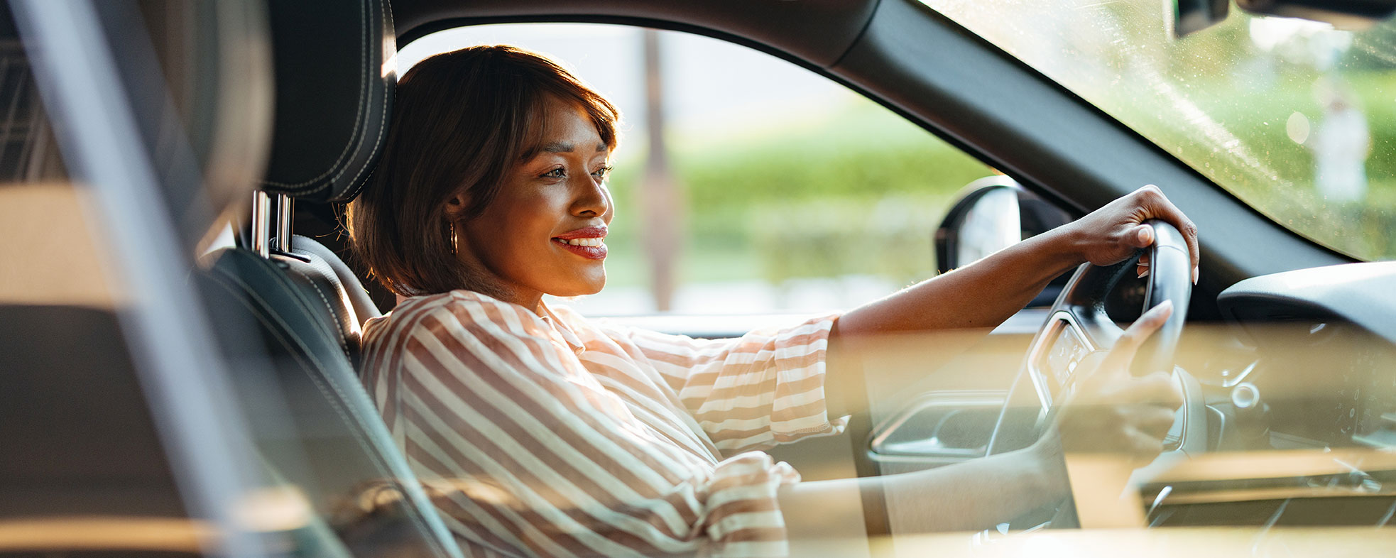 Woman smiling behind the wheel of her car