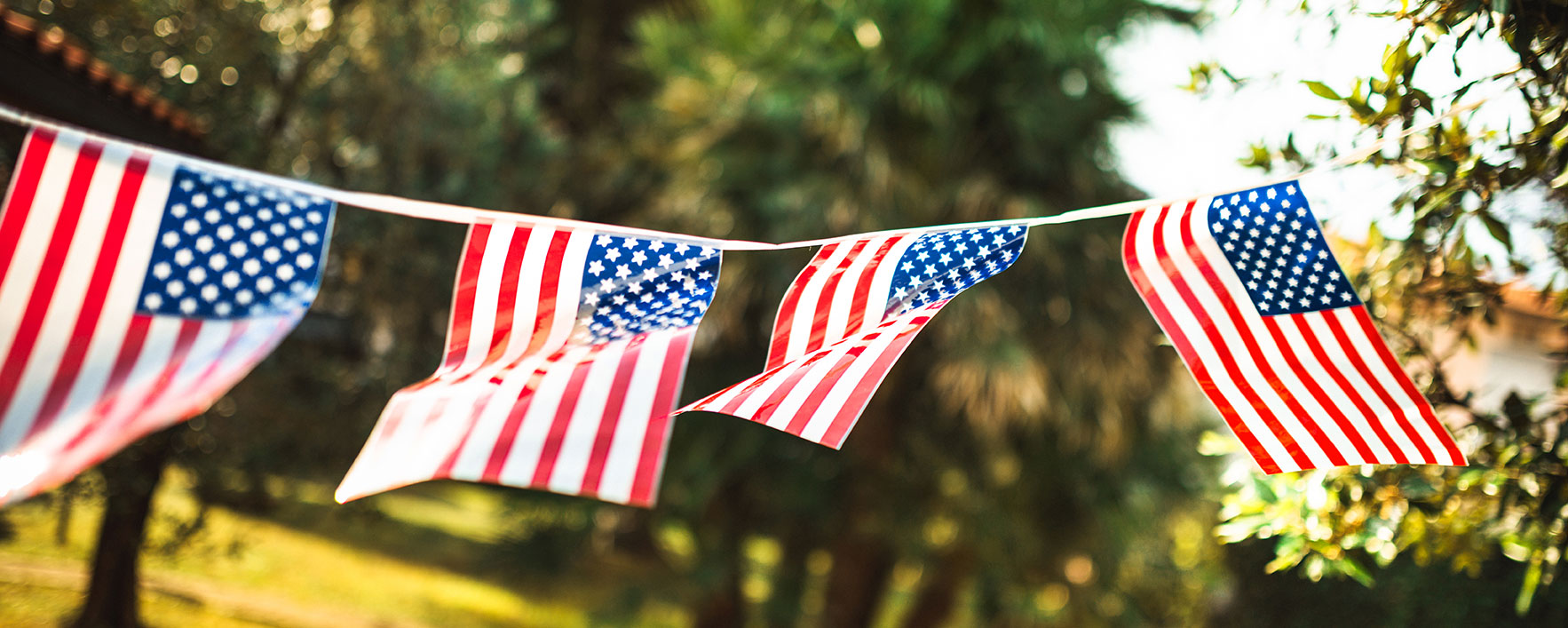 string banner of American flags flapping in the wind on a summer day