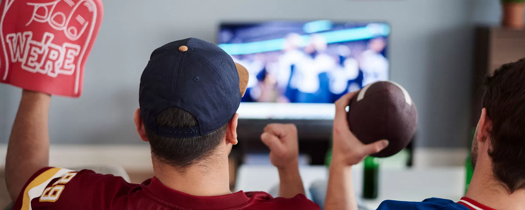 Friends sitting on couch watching football game