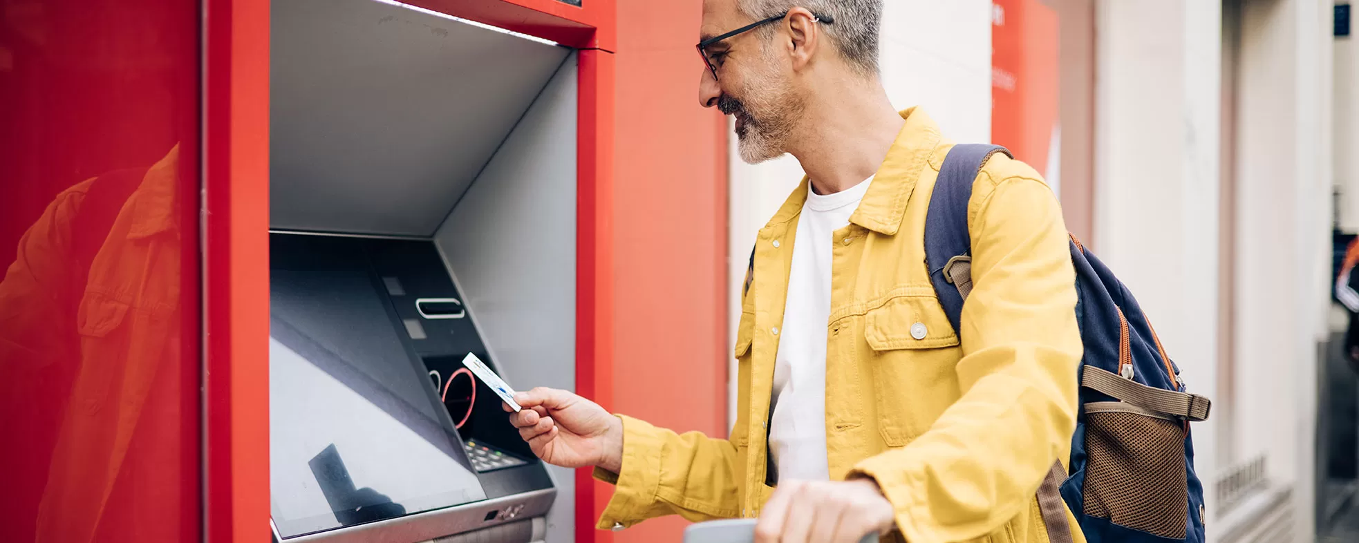 Man using ATM while traveling