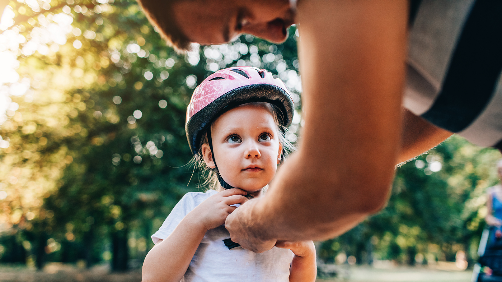 Father putting bike helmet on daughter