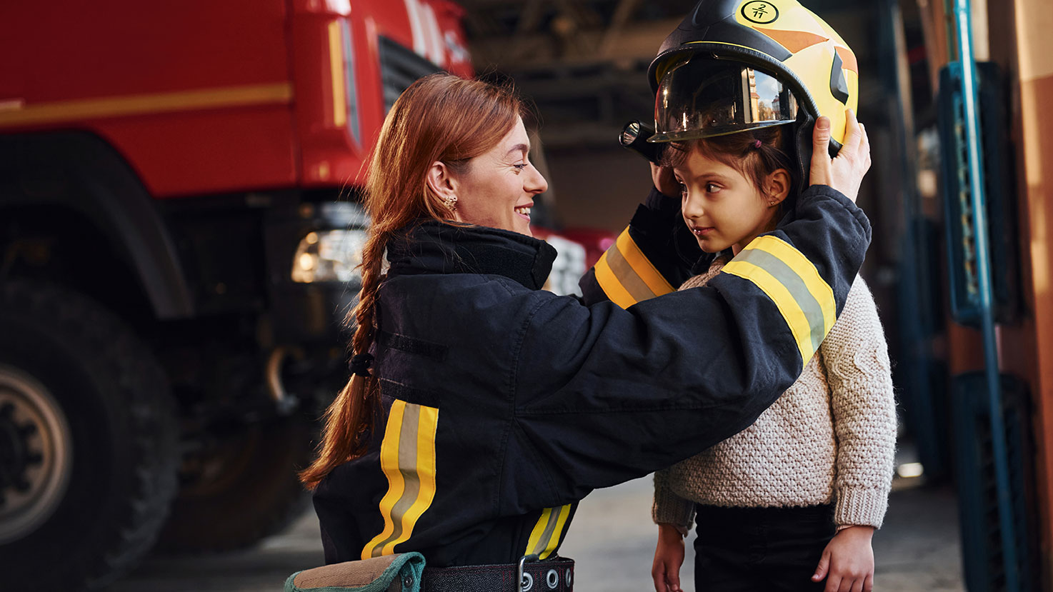 Fire fighter placing hat on child